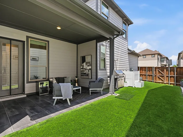 Covered patio with tile flooring and recessed lighting, creating the perfect space for outdoor relaxation and entertaining.