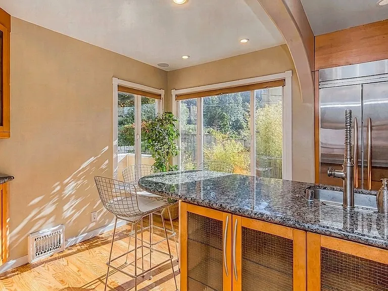 Chef's kitchen on main level with breakfast bar or intimate dinner countertop, flooded with natural light. Window to the 1st floor outside deck looking over the garden.
