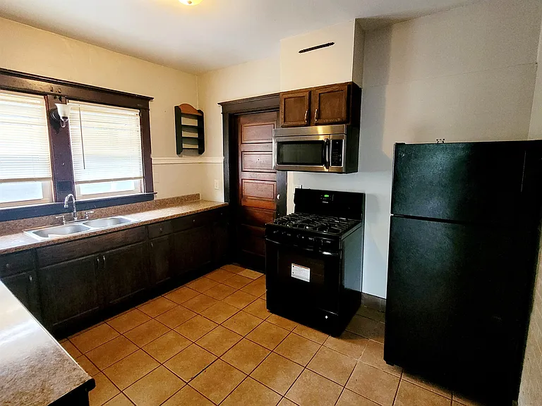 Kitchen w/ rear staircase access to the basement/laundry area