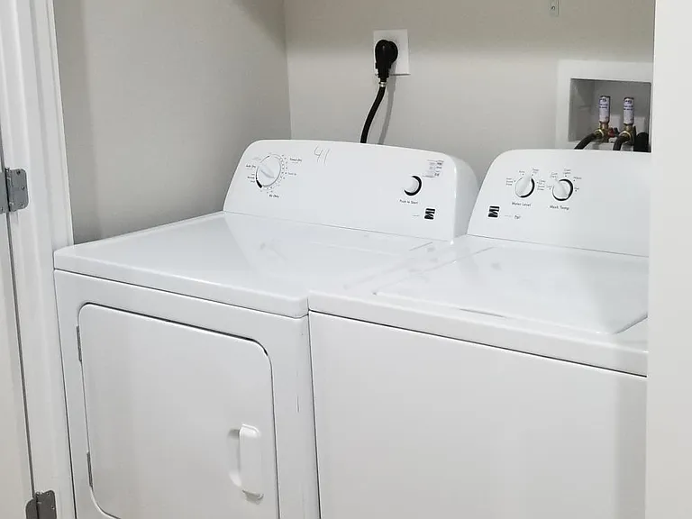 Washer-dryer in unit with lots of above appliance storage space.