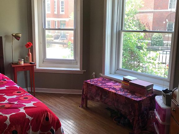 First floor bedroom with hardwood floors, large windows and high ceilings