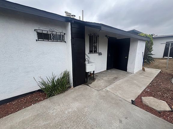 Back of house where washer and dryer hook up, carport and extra storage cabinet