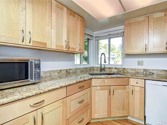 Farm Style Kitchen Sink and Pull Down Faucet looks out 2 kitchen windows.