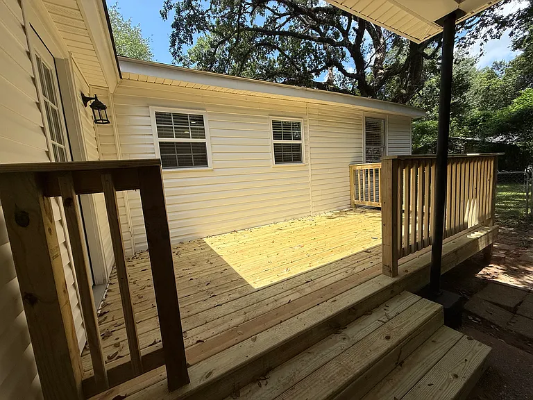 New side deck connecting carport to the mudroom highlighting the kitchen windows