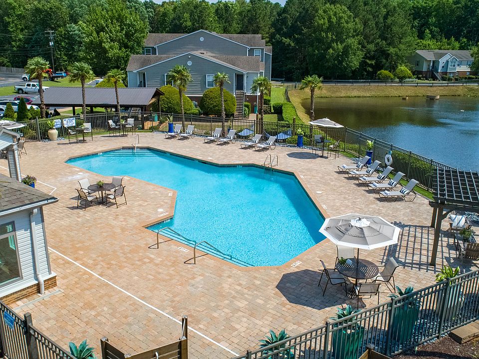 An aerial view showcases our gleaming pool, lush greenery, and serene lakeside charm.