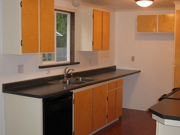 Kitchen has lots of lighting, new counter tops, and a stainless steel sink.
