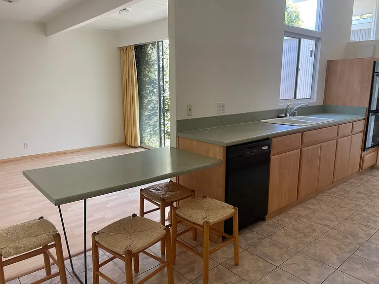 Photo taken from the kitchen with the living room in the background, dishwasher also shown