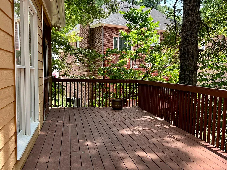 Large deck facing wooded backyard.