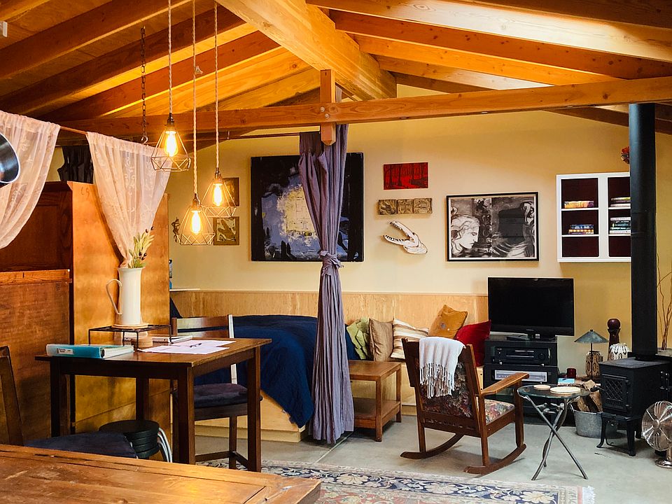 Kitchen counter (foreground), table, bed, TV, fireplace.