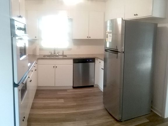 Granite countertops with stainless appliances in kitchen with eat-in area.