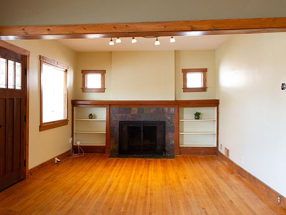 Living room with wood-burning fireplace and built-in bookshelves.