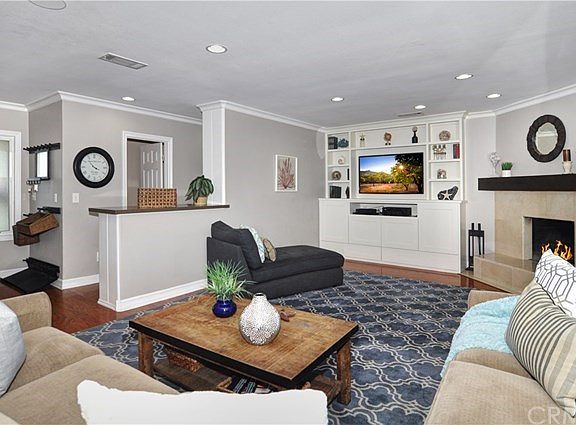 Family Room with built-in wall unit entertainment center and a cozy fireplace. House bathroom door shown in background.