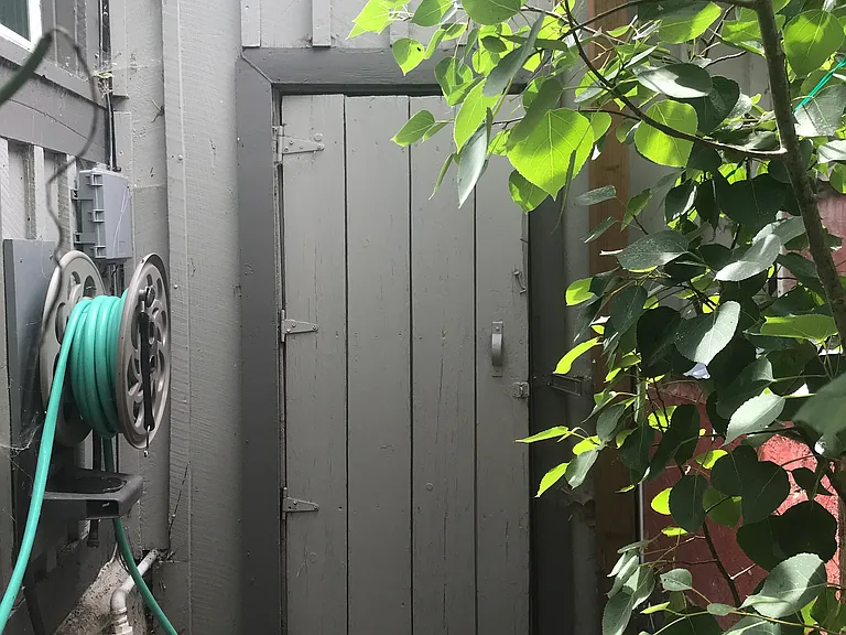 Back door to utility shed, original build which historically was used as metal workshop and barn. Great for gear, workshop, storage, and even workout equipment. To the left is the chicken coop and run area.