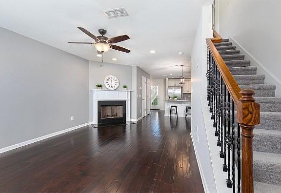Spacious entryway into the home with stairs leading to the second floor. These hardwoods are beautiful.