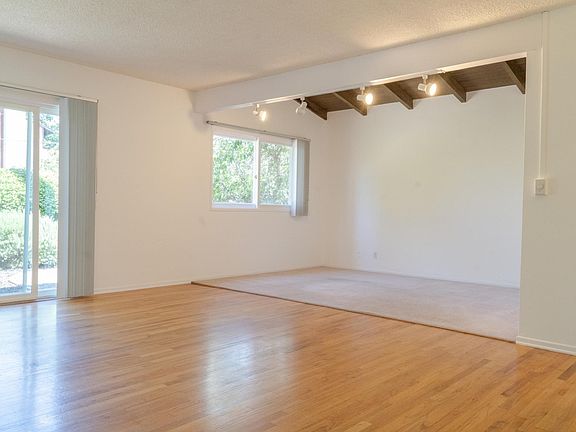 Den space with wood-beamed, vaulted ceiling