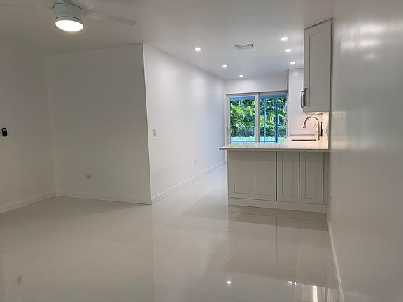 A view from the living room, through the kitchen and the sliding glass doors to the Florida Room and the backyard.