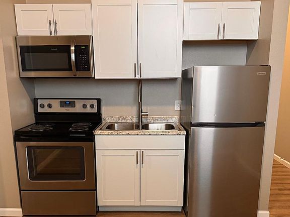 Modern kitchen with stainless steel appliances, sleek cabinetry, and granite countertops in a compact design. Modern kitchen with stainless steel appliances, sleek cabinetry, and granite countertops in a compact design.