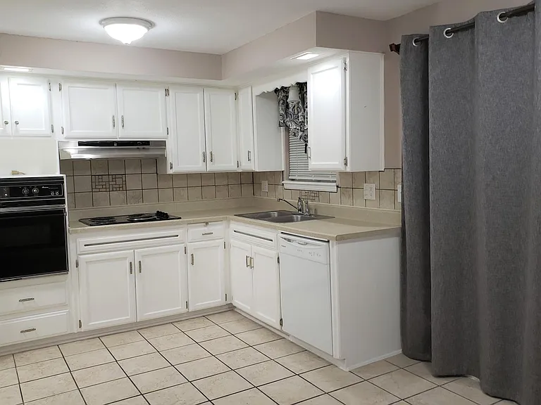 Bright large kitchen with dishwasher, oven, cooktop, and microwave.