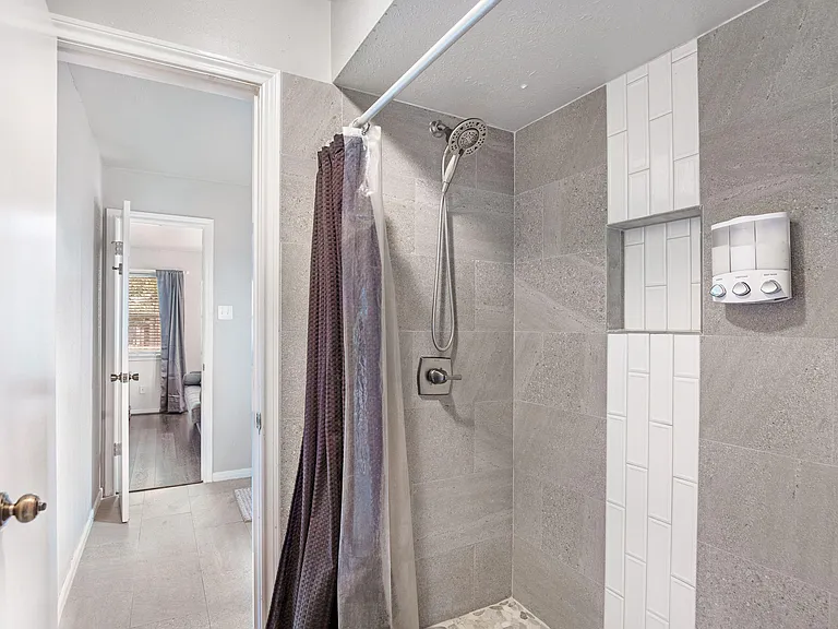 Tiled walk-in shower with handheld showerhead, built-in niche shelving, and durable finishes for easy daily use.