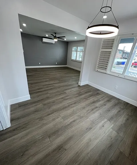 Dedicated dining room with contemporary chandelier and plantation shutters
