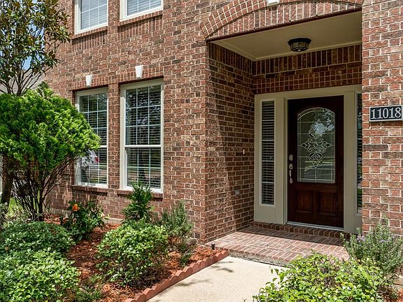 Manicured flowerbeds with lush landscaping welcomes you to the charming front porch!