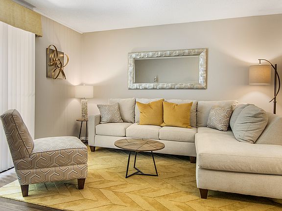 Living room with a couch and comfy chair at Magnolia Crossing apartments for rent