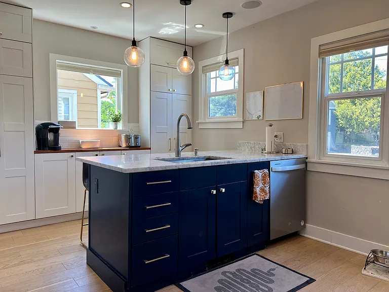 Open flow kitchen with eat-in bar, marble countertops, overhead pendant lighting and stainless steel appliances. Lots of additional storage.