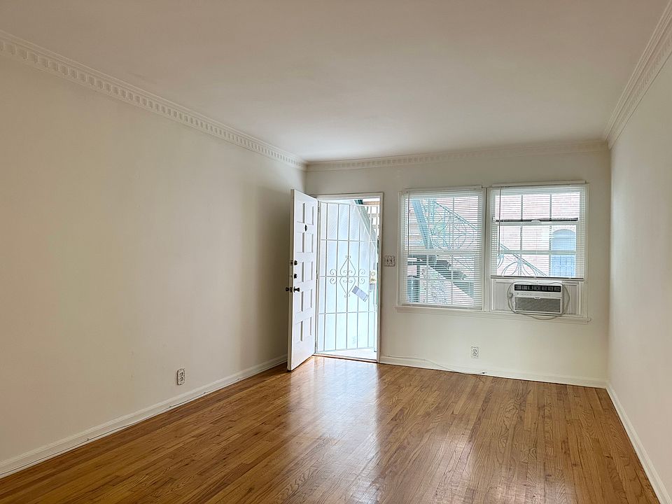 Main Living Area with large windows and screen door. Original wood floors.