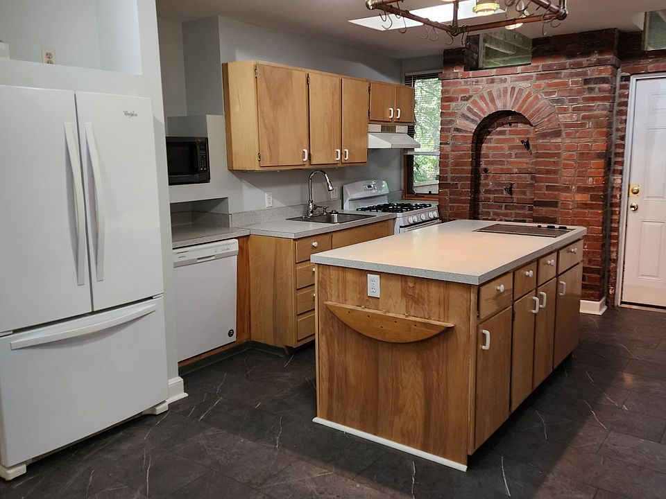 One side of Kitchen with Large Kitchen Island and beautiful wall brick work.