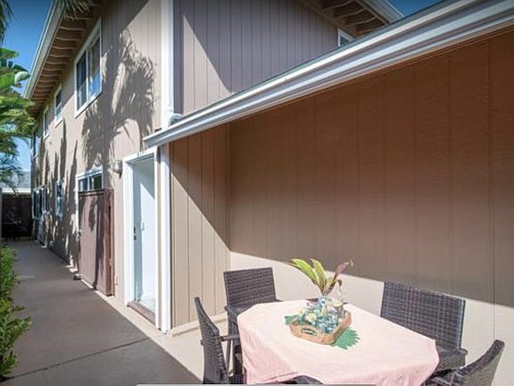 Entrance to the condo on the left side of the driveway. The first door is for the upstaris condo, with storage or seating area where you see this table. There is a gate that is open in this picture that leads to the door for the downstairs condo.