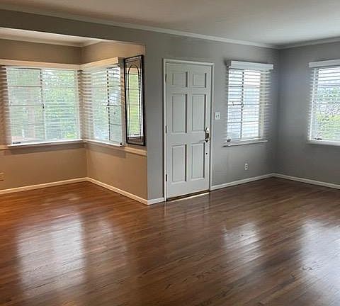 Open concept living and dining room with plenty of natural light, fresh pain my and beautiful hardwood floors