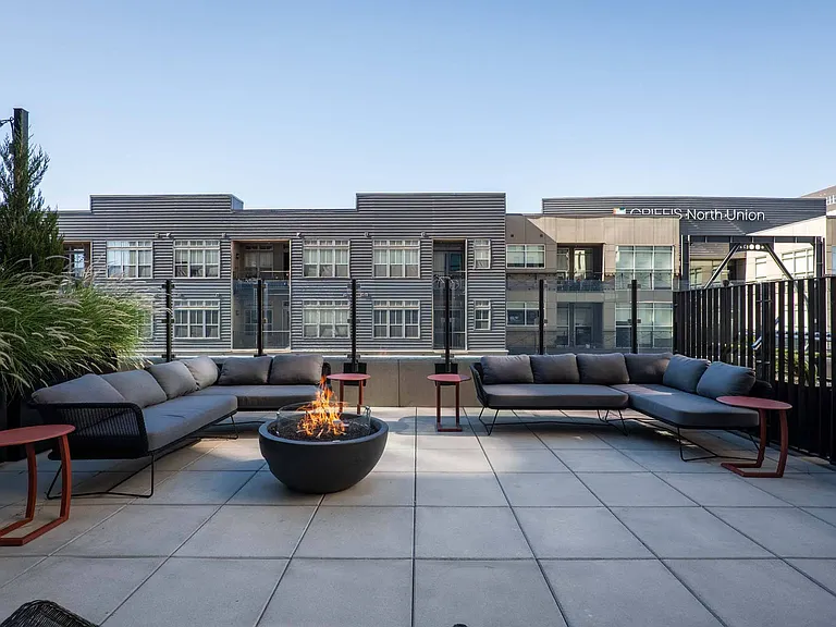 Unwind on a huge couch around a cozy fire pit on the spacious patio, perfect for evening gatherings.