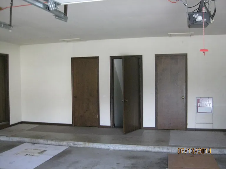 Garage with door down to private basement
