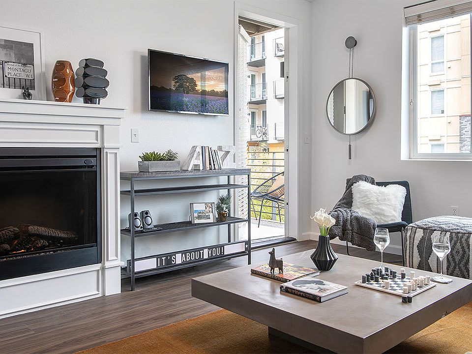 Apartment living room with wood-style flooring, fireplace and balcony.