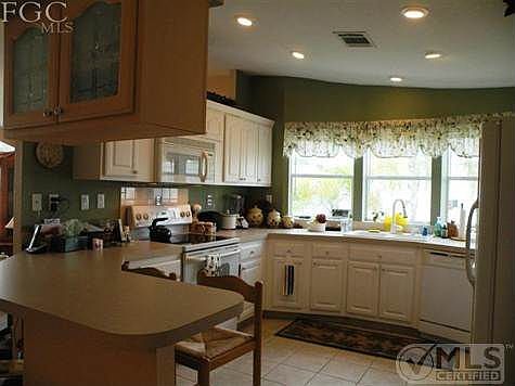Open Kitchen with Bay window, tiled floor and suspended cabinet allowing pass-thru. Lots of storage. Nice appliances.