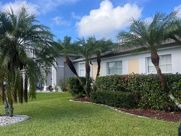Excellent curb appeal with bright skies and green surroundings.