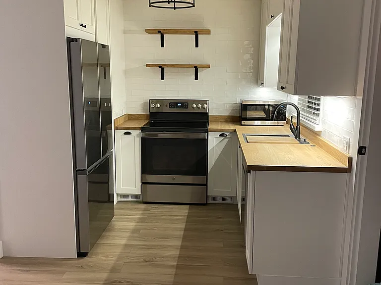Kitchen with pantry, lots of cabinets, large refrigerator with ice maker, stove, microwave, dishwasher, and garbage disposal.