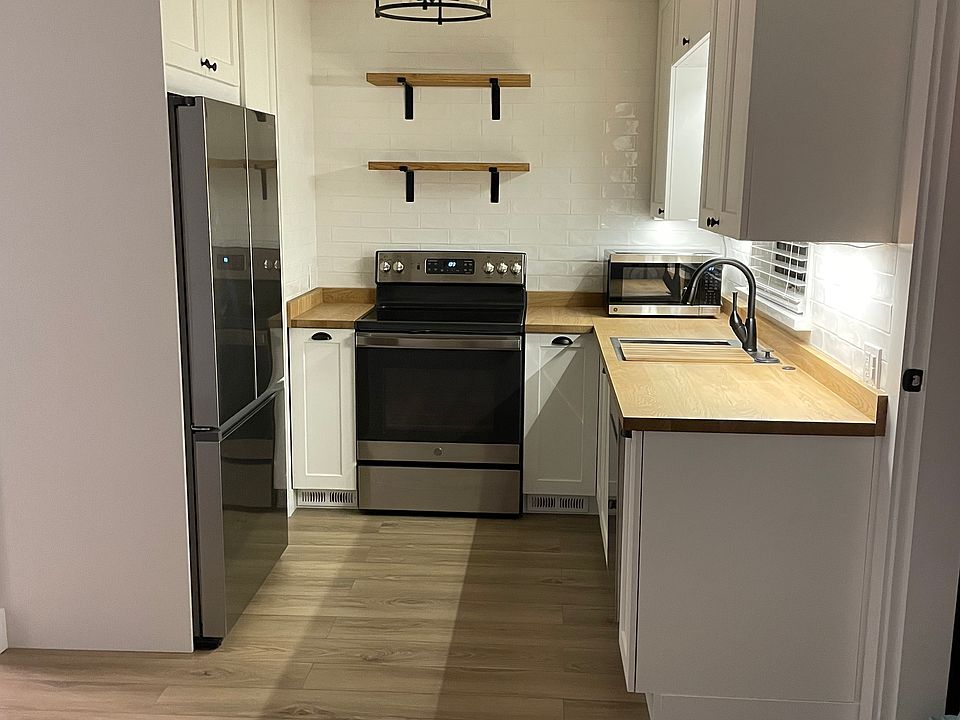 Kitchen with pantry, lots of cabinets, large refrigerator with ice maker, stove, microwave, dishwasher, and garbage disposal.