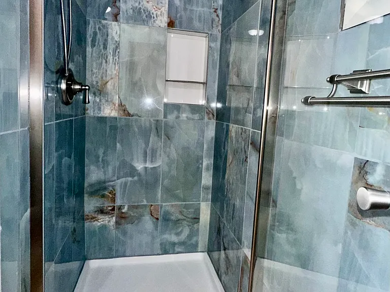 Remodelled bathroom with waterfall shower and handheld extension.