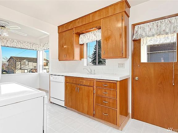 Kitchen has electric range, refrigerator, dishwasher, and microwave. Attached breakfast nook.