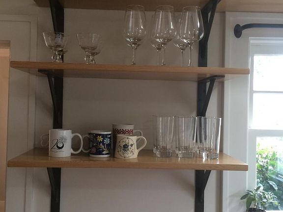 Locally forged, metal brackets and salvaged wood shelving.