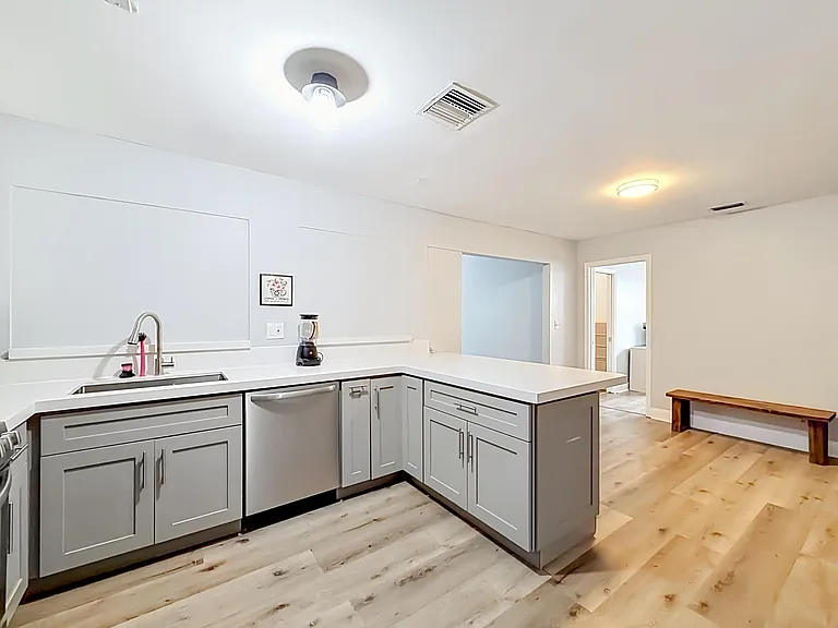 Updated kitchen with ample cabinet storage, dishwasher, and a peninsula counter that opens to the main living area.