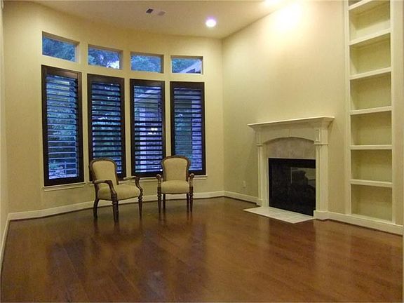 Formal Living Room offers wood floors, high ceilings, plantation shutters and two sided fireplace.