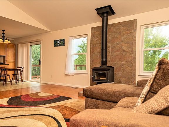 Living room - Spacious with vaulted ceiling, hardwood floors, and wood burning stove.