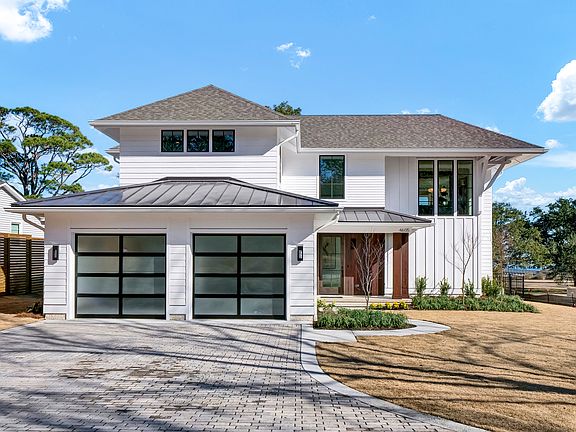 Glass Automatic Garage Doors to pull into the Garage. Brick Pavers, Mahogany Door and Front Porch Siding. See the Water in back!