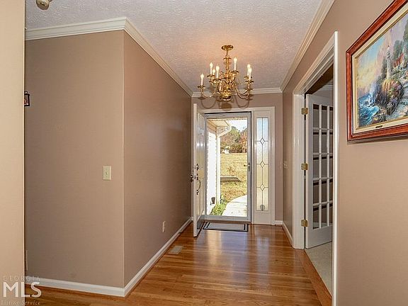 The Entry Foyer with gleaming hardwood floors continues throughout the main Living Room, Kitchen, Ha