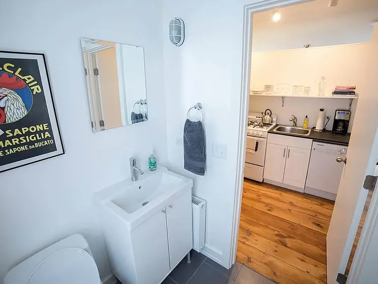 Full bath with tile shower, looking out to kitchen.