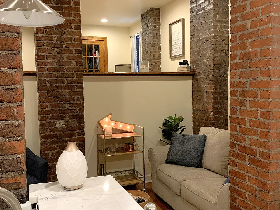 Soft Loft open floor plan with tall ceilings and exposed brick