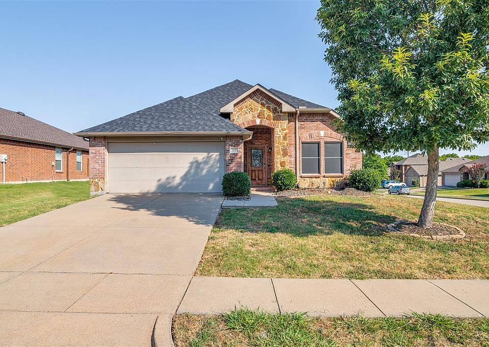 View of front of property with a garage and a front yard
