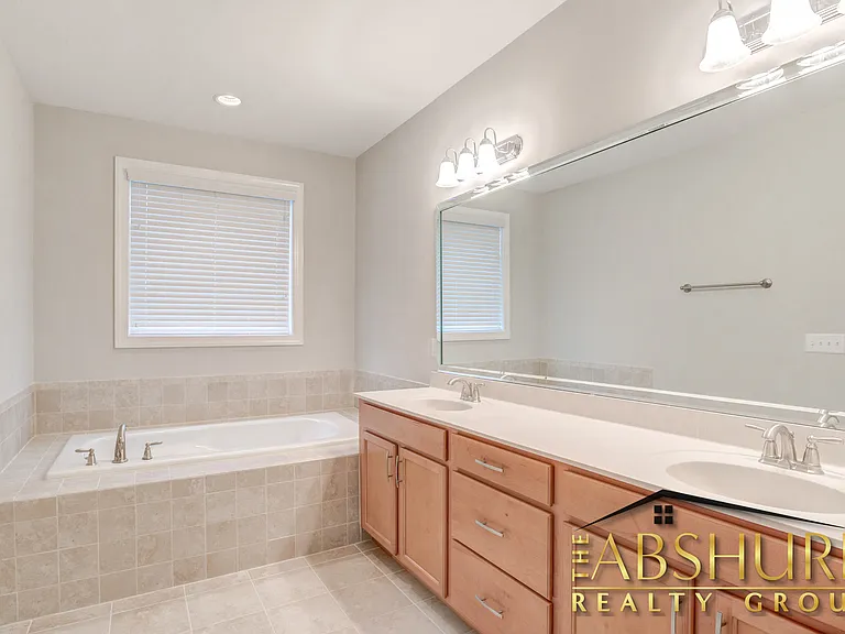Owner's bathroom with dual vanity cultured marble countertops, oversized soaker tub